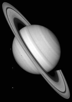 Saturn z widocznymi trzema księżycami: Minasem, Enceladusem i Tethysem© NASA