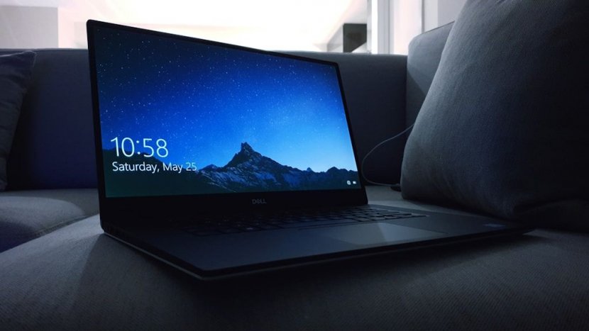 Laptop Dell z podświetlonym ekranem stojący na kanapie